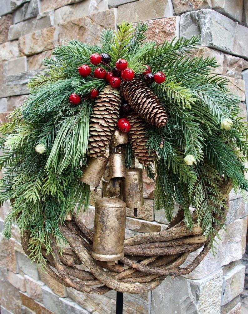 Couronne de porte rustique d'hiver avec clochettes dorées, pommes de pin et baies – Décoration saisonnière style ferme pour entrée ou manteau de cheminée